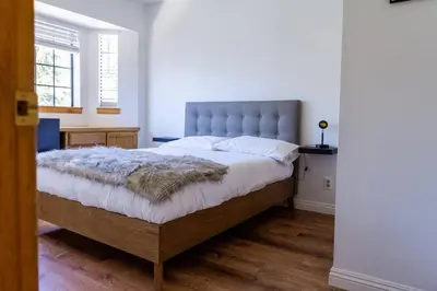 a bedroom with a large bed with a tufted headboard at Apres-Ski Chalet Mt High Wrightwood Ski Resort in Wrightwood