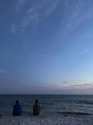two men sitting on the beach fishing in the ocean at Malibu Best Kept Secret in Malibu