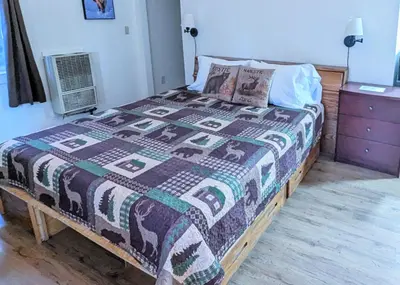 a bed with a quilt on it in a bedroom at Fox n Bear Cottages Big Bear in Big Bear Lake