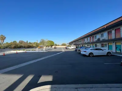 a parking lot with cars parked in front of a building at The Dixie Orange County in Stanton