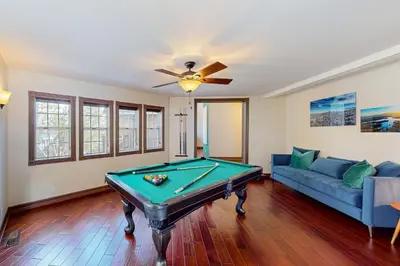 a living room with a pool table and a couch at The Chateau in Lake Arrowhead