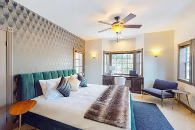 a bedroom with a large bed with a ceiling fan at The Chateau in Lake Arrowhead