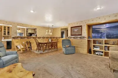 a living room with a couch and a dining room at Big Bear Happy Place~ Hot Tub~ Games~ Walk to Village~ in Big Bear Lake