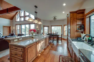 a kitchen with wooden cabinets and a large kitchen island at Pine Mountain Club Cabin with Private Deck and Views! in Pine Mountain Club