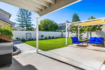 a patio with two blue chairs and an umbrella at Olivia Oasis in Oxnard