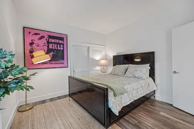 a bedroom with a bed and a poster on the wall at 11 Best Walk location of SM in Los Angeles