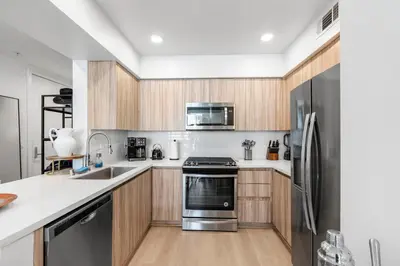 a kitchen with wooden cabinets and a stainless steel refrigerator at 9 Advantages Center Santa Manica in Los Angeles
