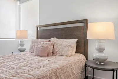 a bedroom with a bed with two lamps and two tables at 9 Advantages Center Santa Manica in Los Angeles