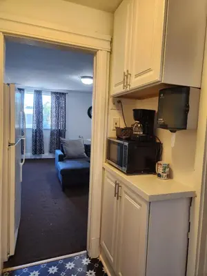 a kitchen with a microwave and a living room at Eight Street Apartments in Long Beach