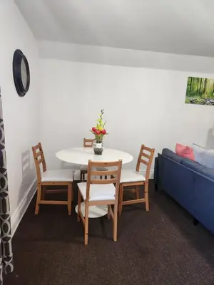 a table and chairs in a living room with a couch at Eight Street Apartments in Long Beach