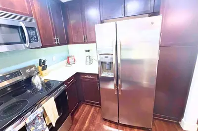 a kitchen with a stainless steel refrigerator and a stove at Super Quiet Apartment In Full Service Bldg near UCLA in Los Angeles