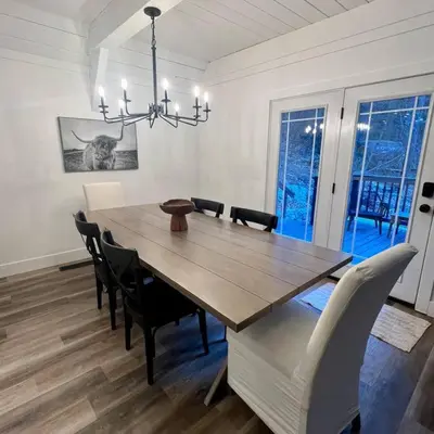 a dining room with a wooden table and chairs at Lake Arrowhead Lux Black Cabin in Lake Arrowhead