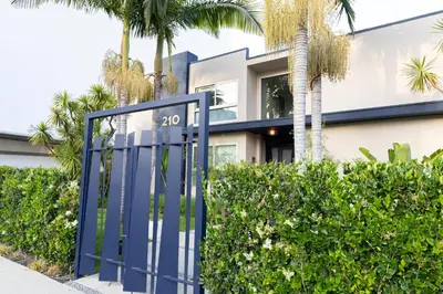a blue gate in front of a building with palm trees at Luxury 2br 2ba Beverly Hills Near Cedars Sinai in Los Angeles