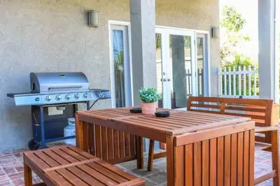 a patio with a grill and a table and benches at Large 5 BR- Beverly Hills Adj in Los Angeles
