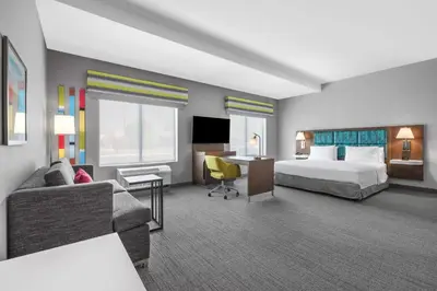 a hotel room with a bed a couch and a desk at Hampton Inn & Suites Bakersfield Central in Bakersfield