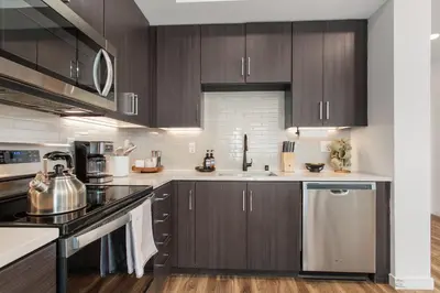 a kitchen with dark wood cabinets and stainless steel appliances at Luxury 1BDR centrally located in Hollywood in Los Angeles