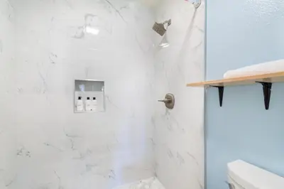 a bathroom with a shower with white marble walls at Thousand Oaks 2br near shopping dining bars LAX-1157 in Oak Park