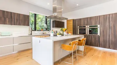 a kitchen with white cabinets and a island with chairs at Luxe WeHo Villa Walk to Melrose Ave Pool Hot Tub North Vista by AvantStay in Los Angeles