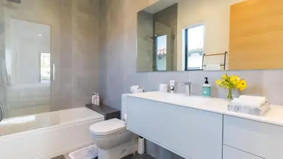 a bathroom with a sink and a toilet and a mirror at Luxe WeHo Villa Walk to Melrose Ave Pool Hot Tub North Vista by AvantStay in Los Angeles