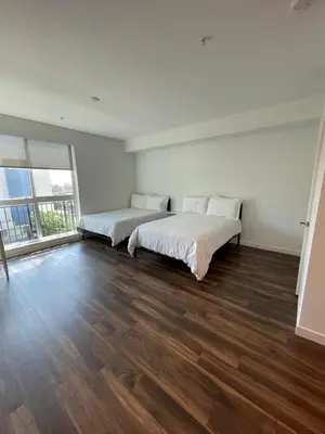 a bedroom with two beds and a large window at Cozy Loft Sunset FRRE WIFI and DESIGNATED Parking in Los Angeles