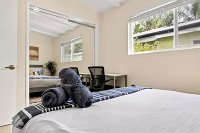 a teddy bear laying on a blanket on a bed at Charming Zen Venice Beach 3BR Home w/Patio & W/D in Los Angeles