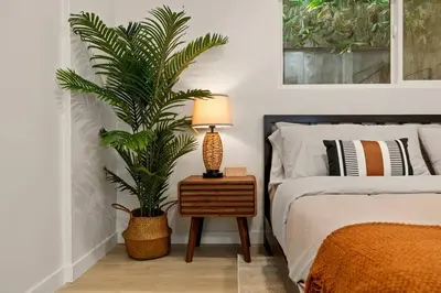 a bedroom with a bed and a table with a plant at Charming Zen Venice Beach 3BR Home w/Patio & W/D in Los Angeles