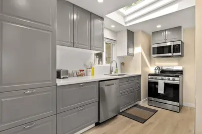 a kitchen with stainless steel appliances and gray cabinets at Charming Zen Venice Beach 3BR Home w/Patio & W/D in Los Angeles