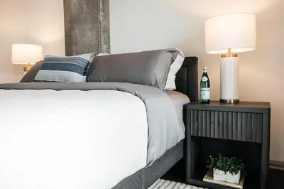 a bedroom with a bed with a lamp and a bottle of wine at Luxurious Hollywood condo in Los Angeles