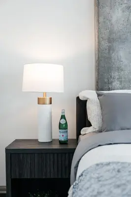 a lamp on a night stand next to a bed at Luxurious Hollywood condo in Los Angeles