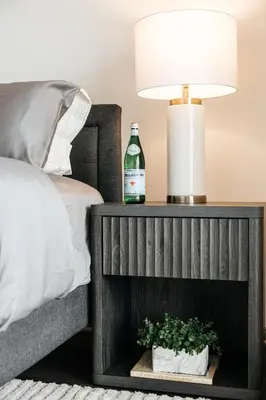 a bottle of alcohol on a table next to a bed at Luxurious Hollywood condo in Los Angeles