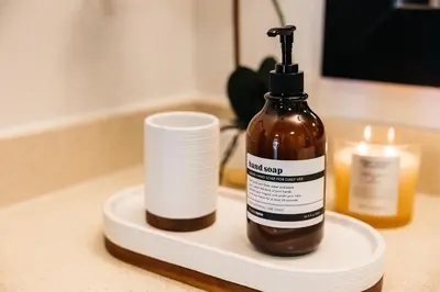 a bottle of liquid soap and a cup on a counter at Luxurious Hollywood condo in Los Angeles