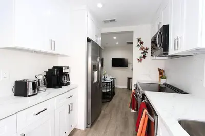 a kitchen with white cabinets and a stainless steel refrigerator at NEW! 2-Bedroom Fontana Guest House close to Kaiser Permanente in Fontana