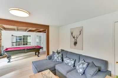 a living room with a couch and a pool table at Crestline Home with Private Hot Tub Steps to Lake! in Crestline