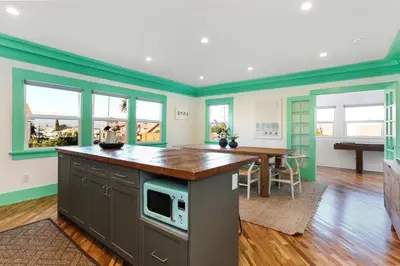 a kitchen with green walls and a table with a microwave at Peace Palace 4803 in Los Angeles