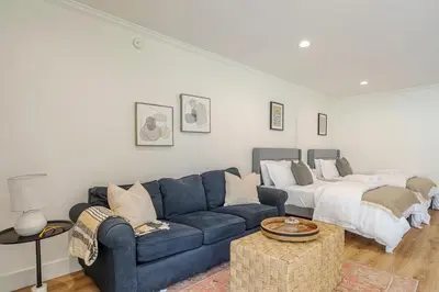 a living room with a blue couch and a bed at New Home Universal sleeps 18 hot tub in Los Angeles