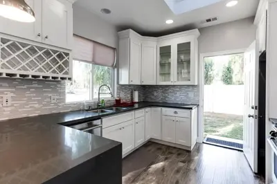 a kitchen with white cabinets and a black counter top at Lake Balboa 7 Bedroom 5 Bathroom Compound in Los Angeles