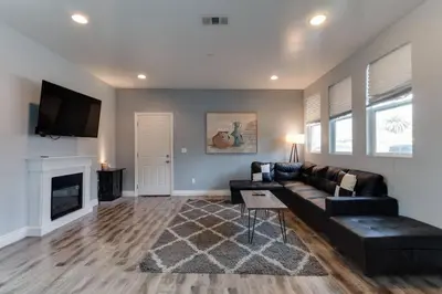 a living room with a black couch and a fireplace at Lake Balboa 7 Bedroom 5 Bathroom Compound in Los Angeles
