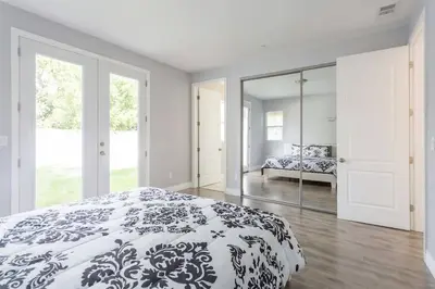 a bedroom with a black and white bed and a mirror at Lake Balboa 7 Bedroom 5 Bathroom Compound in Los Angeles