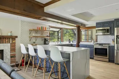 a kitchen with blue cabinets and white bar stools at Lake Reflection Point Upscale Lake House 4 Bed and 4.5 Bath in Lake Arrowhead