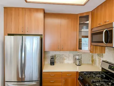 a kitchen with wooden cabinets and a stainless steel refrigerator at *WEHO/Beverly Hills* Luxury 2BD/2.5BA + Balconies in Los Angeles