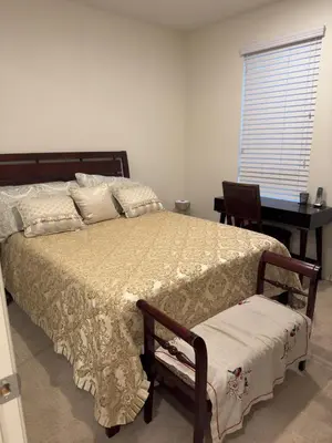 a bedroom with a large bed with a desk and a window at 3 Bedroom Townhome with Large Living Area in Downey