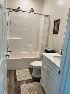 a bathroom with a toilet and a tub and a sink at 3 Bedroom Townhome with Large Living Area in Downey