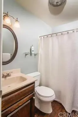a bathroom with a toilet and a sink and a mirror at Large Comfy Family cabin-Great Kitchen, Pool Table, Pets welcome in Lake Arrowhead
