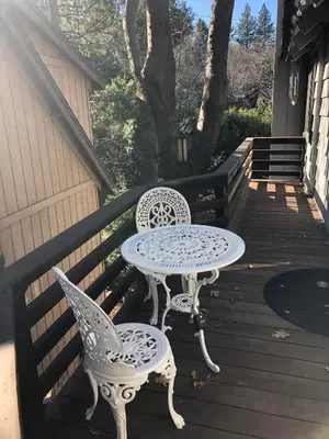 a table and two chairs sitting on a porch at Large Comfy Family cabin-Great Kitchen, Pool Table, Pets welcome in Lake Arrowhead