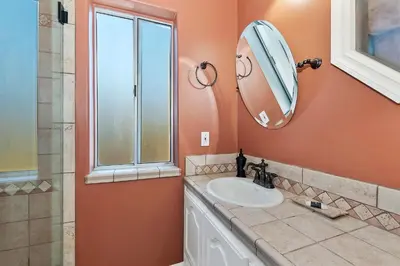 a bathroom with a sink and a mirror at Large Comfy Family cabin-Great Kitchen, Pool Table, Pets welcome in Lake Arrowhead