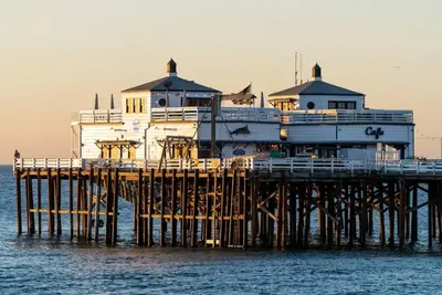 a building on top of a pier in the water at Malibu Sand Carbon Beach Suites in Malibu