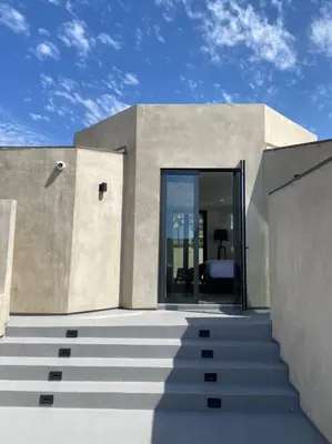 a building with stairs leading to a glass door at Malibu Sand Carbon Beach Suites in Malibu