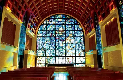 a large stained glass window in a church with pews at Villa Graziadio Executive Center at Pepperdine University in Malibu