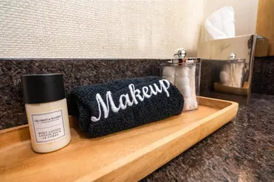a wooden cutting board with a bottle of makeup and a brush at Villa Graziadio Executive Center at Pepperdine University in Malibu