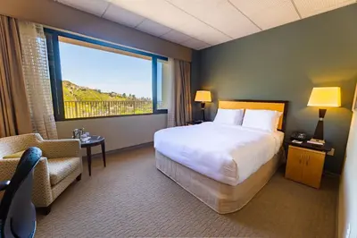 a hotel room with a bed and a chair and a window at Villa Graziadio Executive Center at Pepperdine University in Malibu